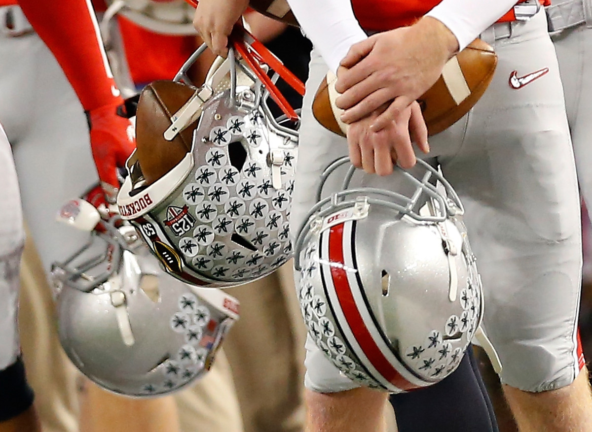 Ohio State players holding their helmets before a game.