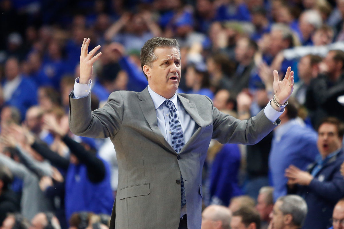 Kentucky basketball's Coach Cal throwing his arms up in the air.