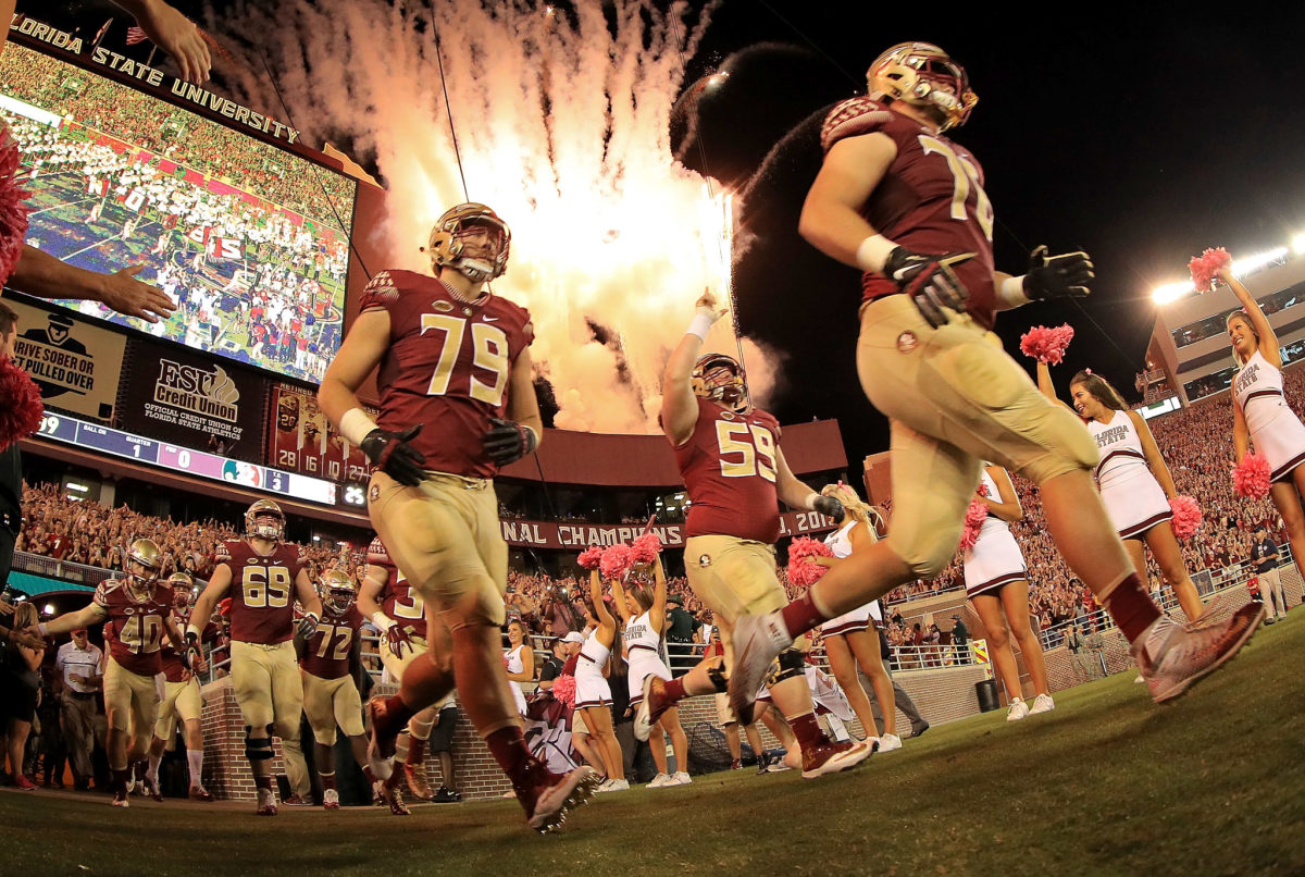 The Florida State football team running onto the field.