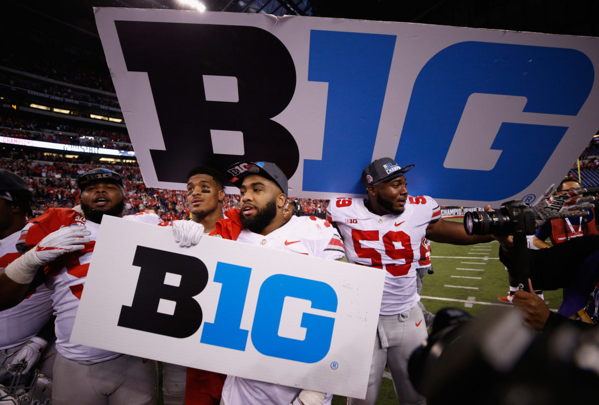 Ohio State football players carrying Big Ten football signs.