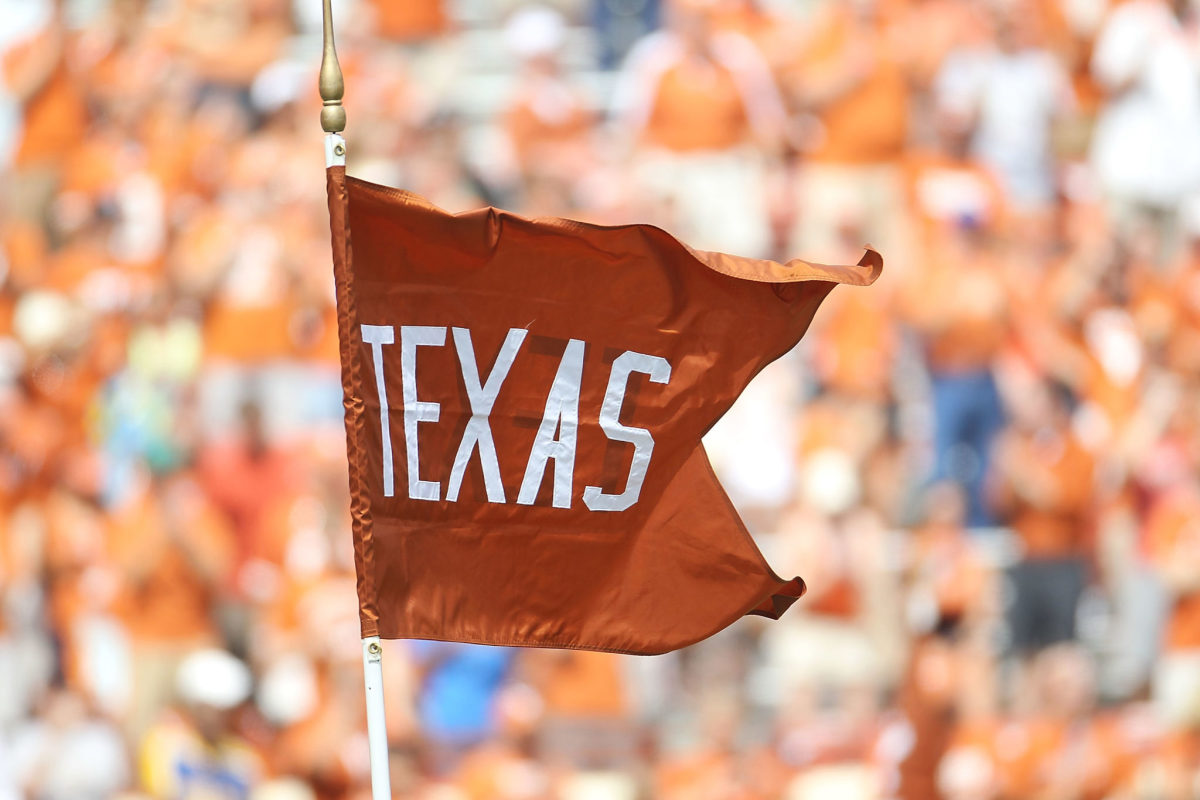 A flag being held during a Texas Longhorns with the team's logo on it.