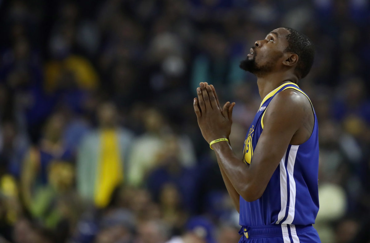 Kevin Durant holding his hands as if he was praying during a game.