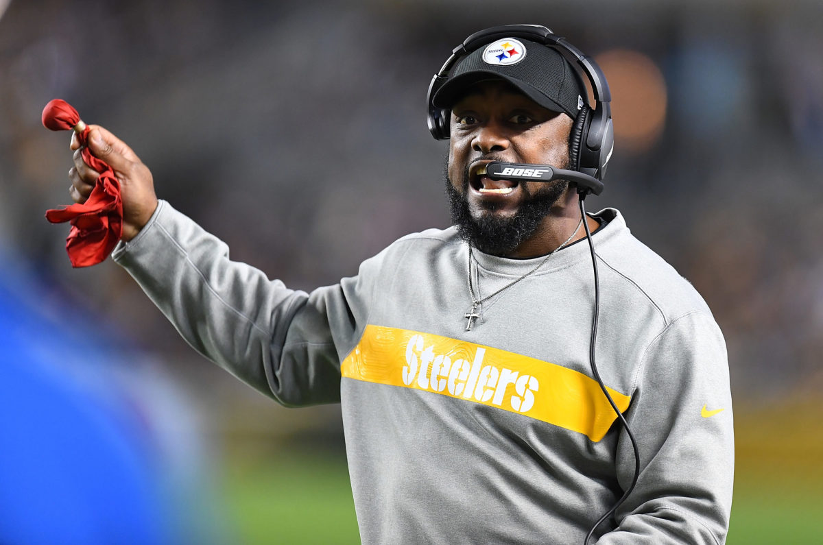 A closeup of Pittsburgh Steelers coach Mike Tomlin holding a challenge flag.