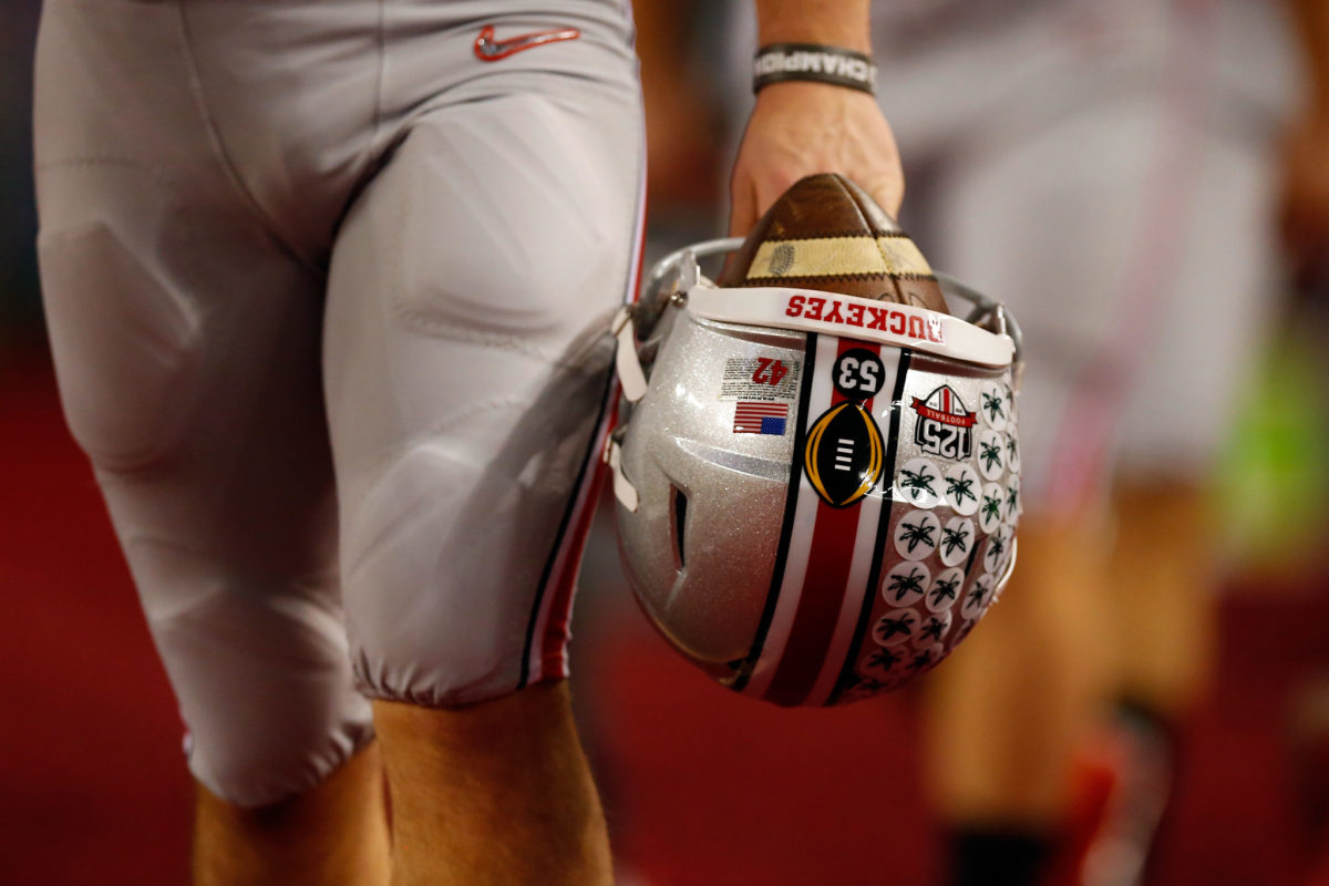 An Ohio State player holding his helmet.