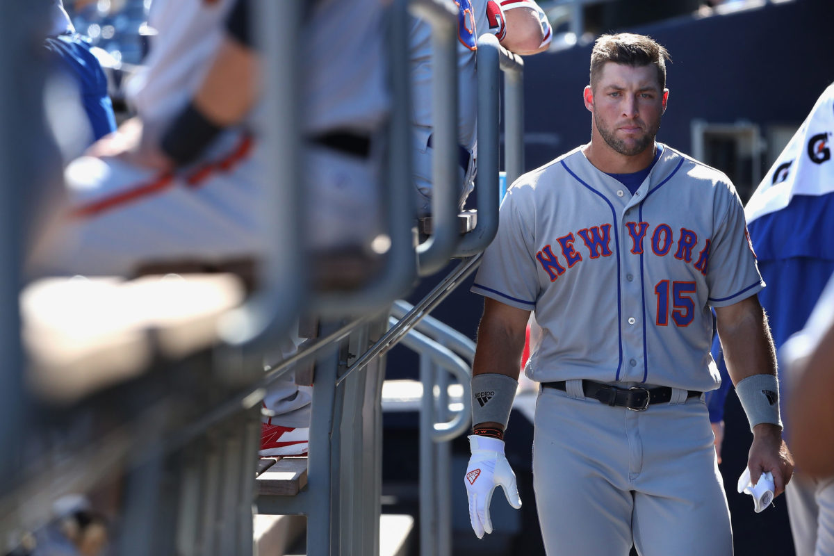 Tim Tebow walking in the dugout.
