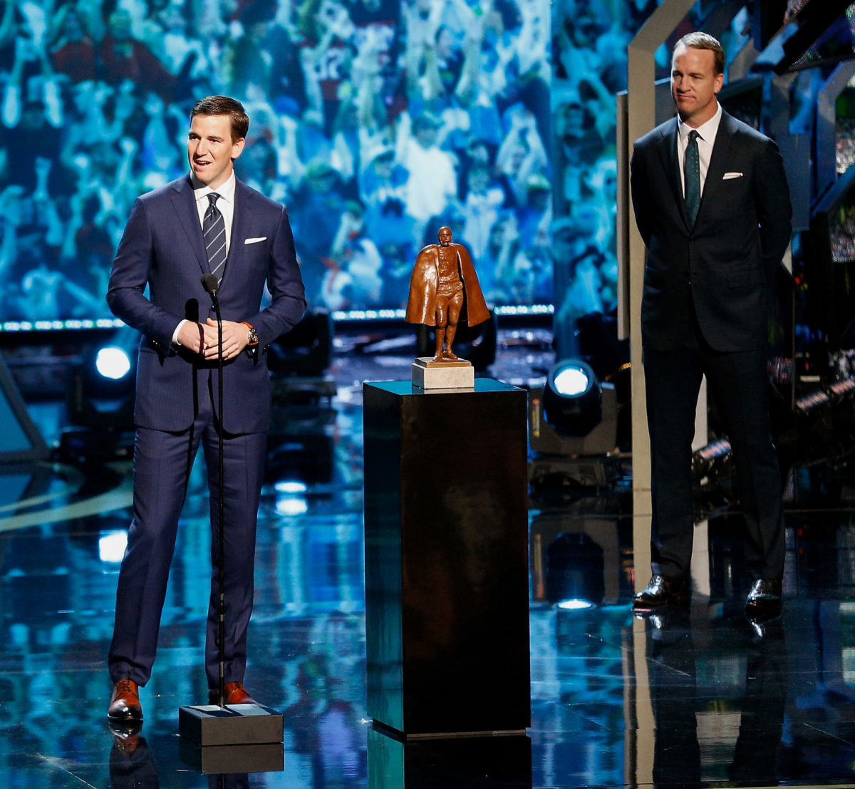 Eli and Peyton Manning on stage at an awards show.