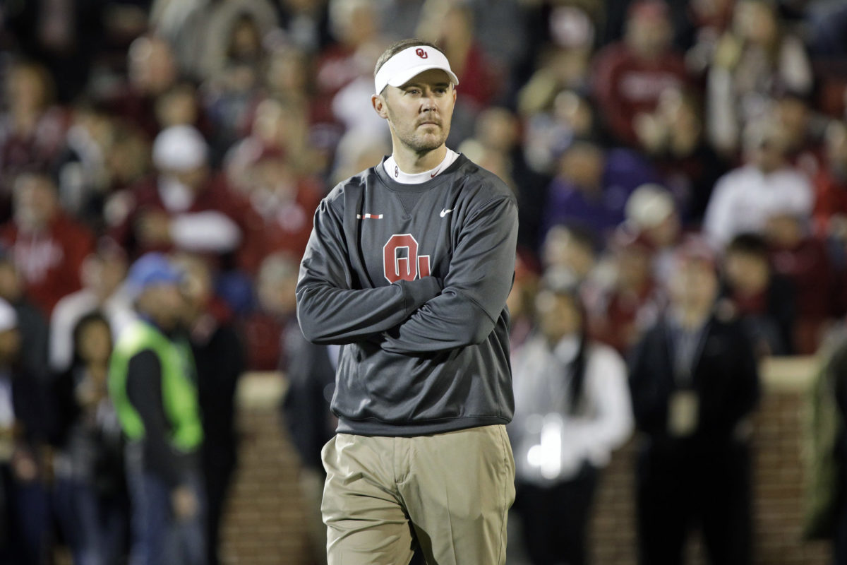 A closeup of Lincoln Riley wearing an Oklahoma Sooners sweater.