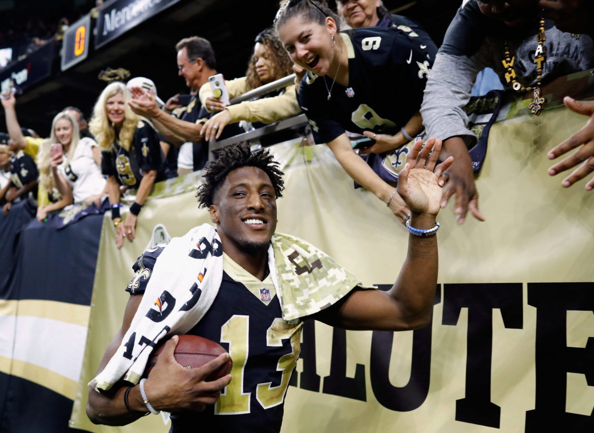 Michael Thomas interacting with fans after a Saints game.