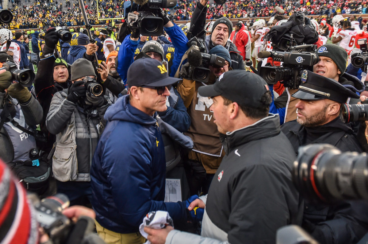 Michigan coach Jim Harbaugh and Ohio State football coach Ryan Day on the field after the game.