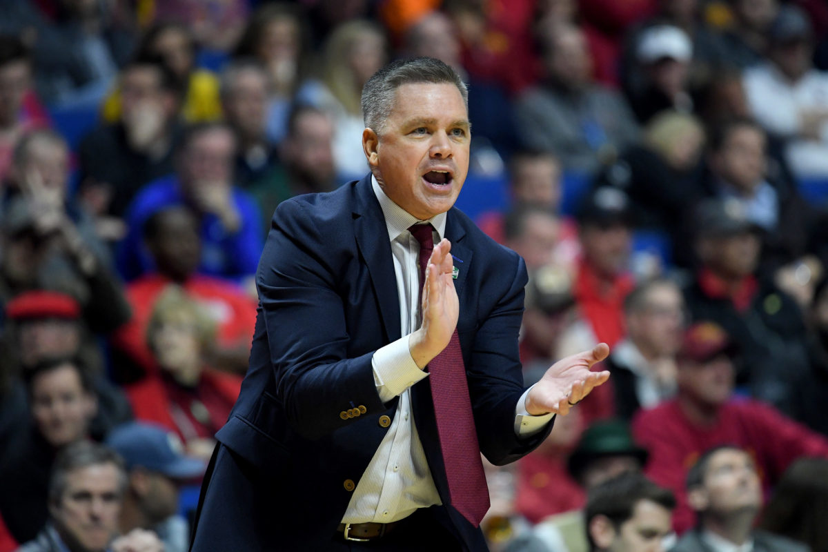 A closeup of Ohio State basketball coach Chris Holtmann clapping during a game.