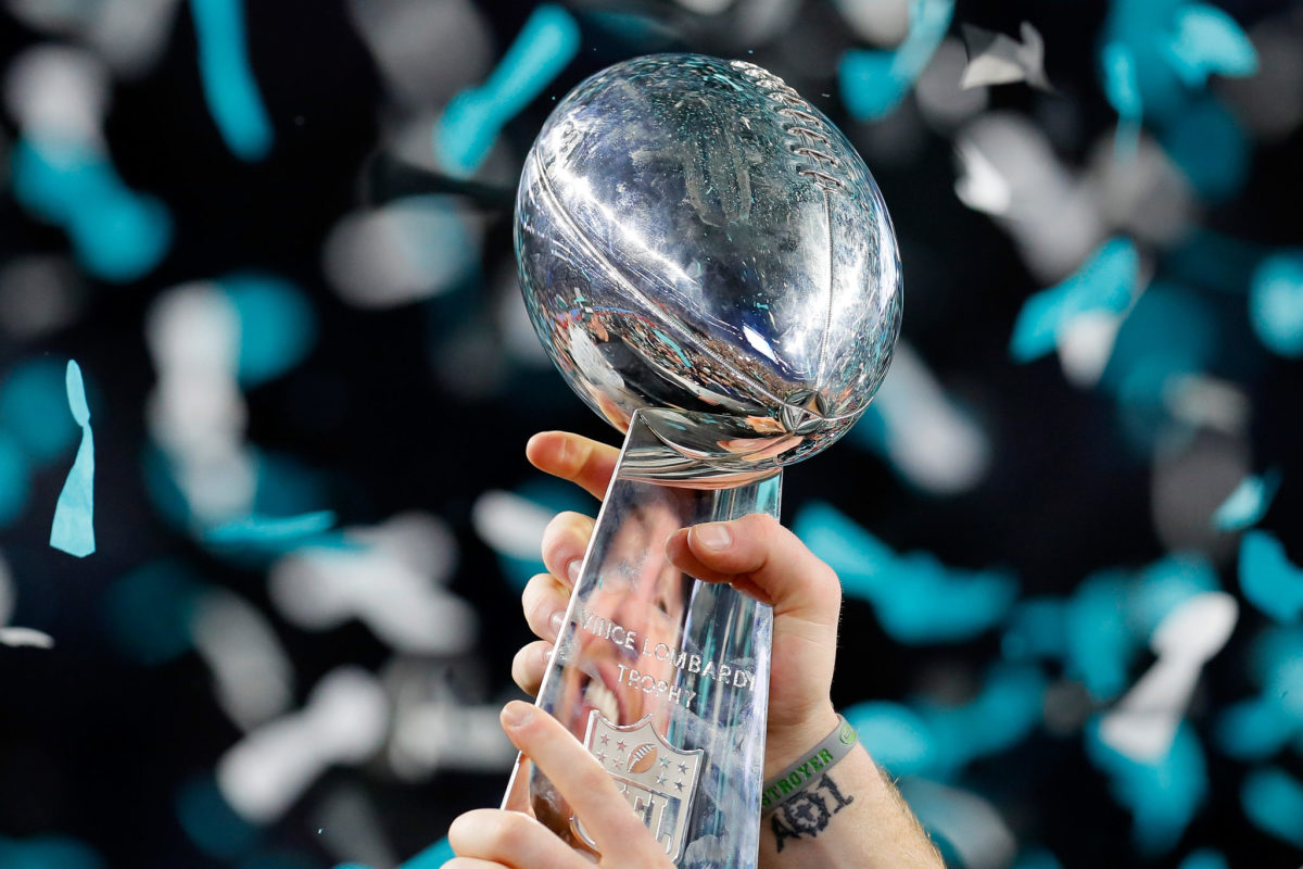 A closeup photo of the Super Bowl trophy with Eagles colored confetti in the background.