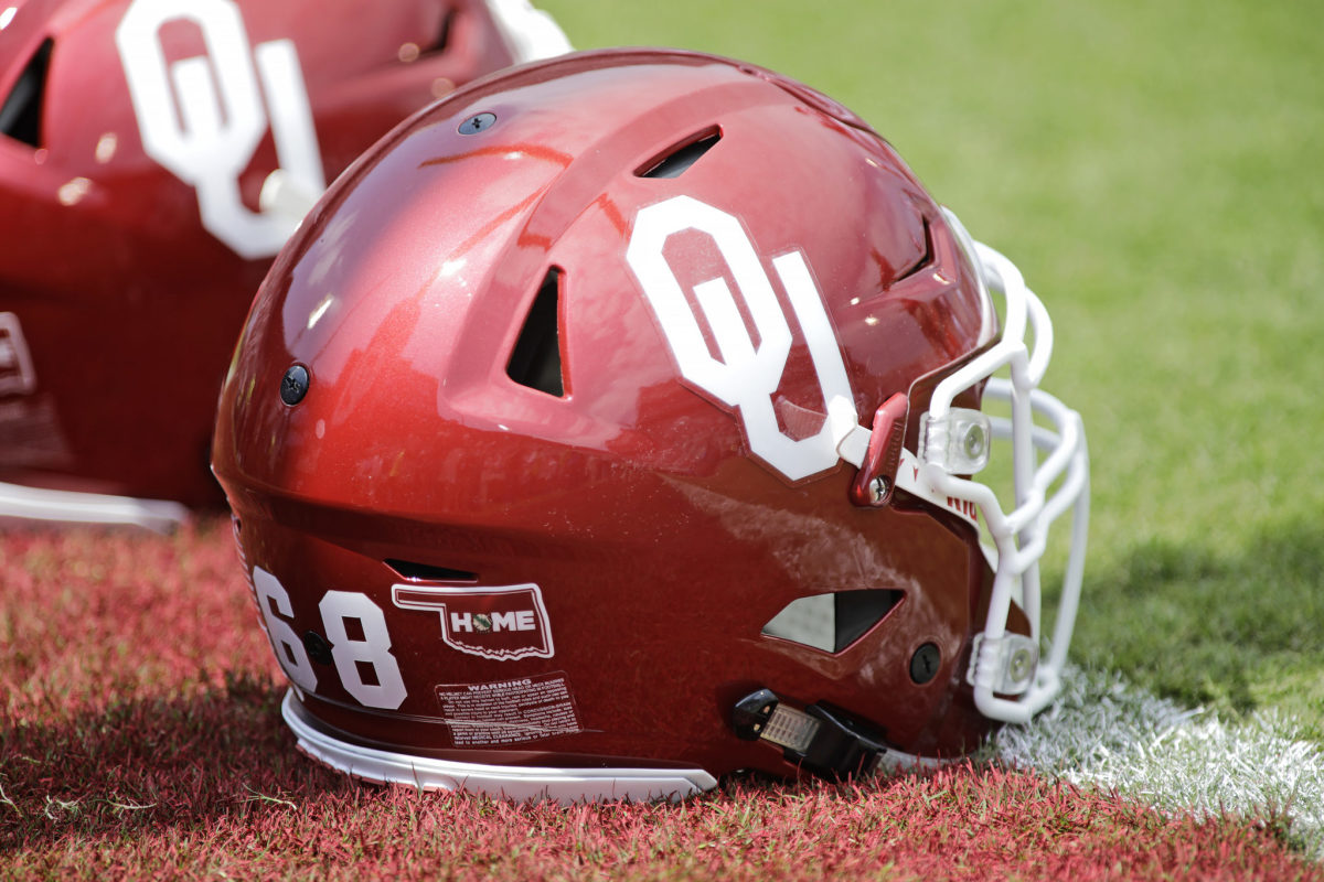 An Oklahoma Sooners helmet sitting on the field.