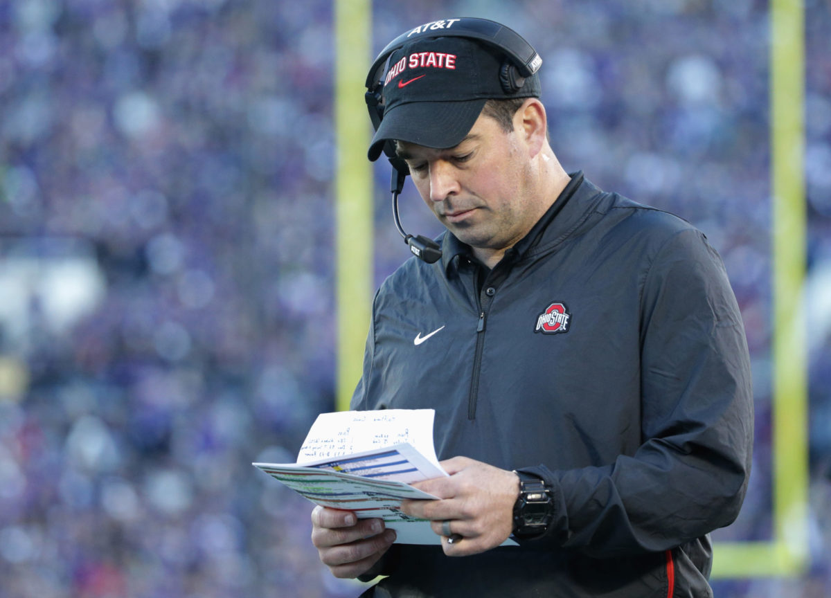 Ohio State coach Ryan Day looking over his notes during a football game.