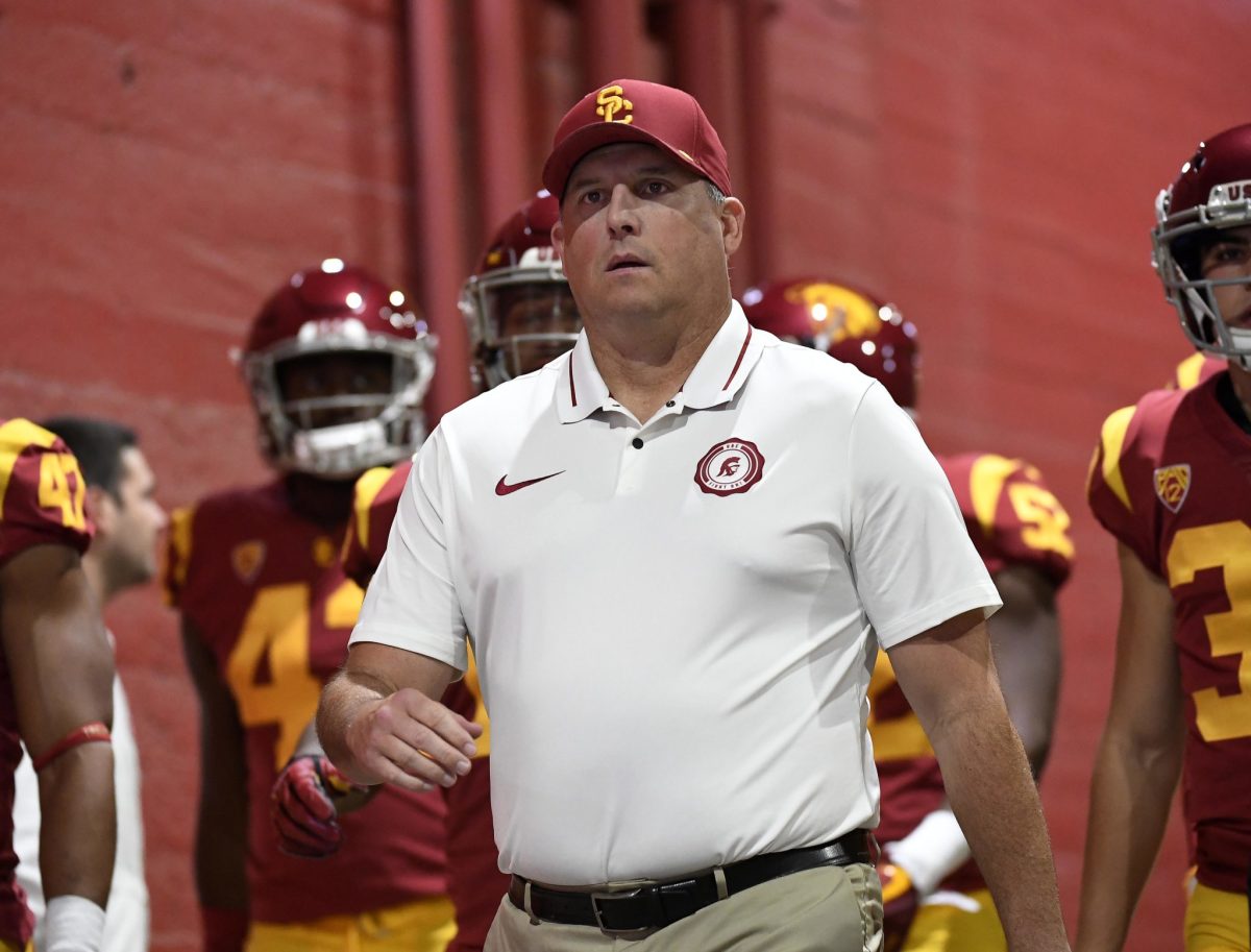 Clay Helton leading the USC Trojans onto the college football field.