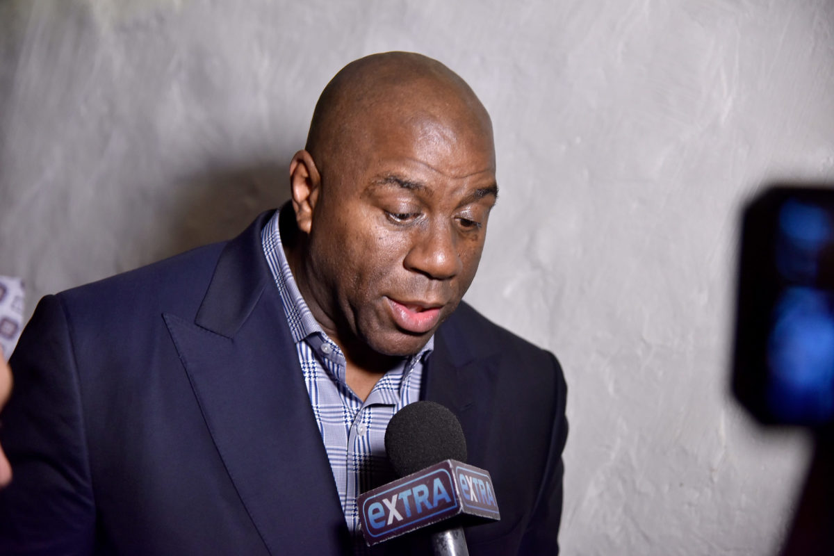 Magic Johnson speaks with reporters at an event.