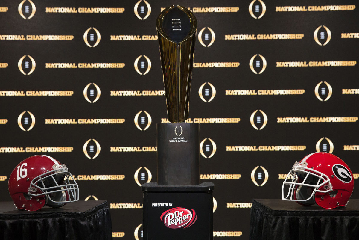 Detail of the College Football Playoff National Championship trophy, along with the helmets of the 2 competing teams, Alabama and Georgia.