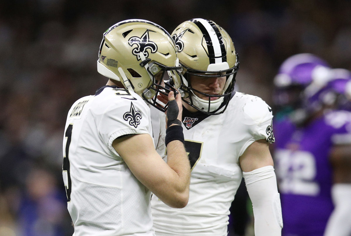 New Orleans Saints quarterbacks Taysom Hill and Drew Brees discuss a play during playoff game vs. the Vikings.