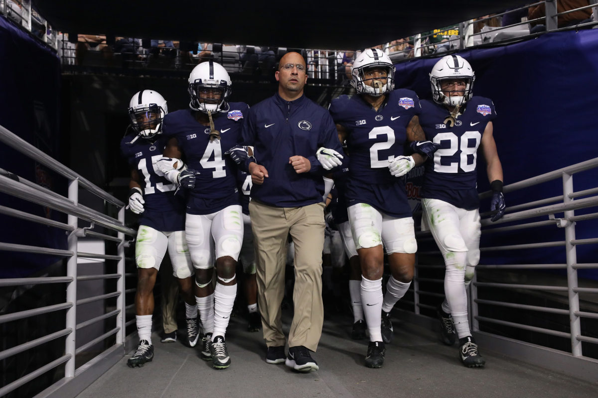 James Franklin walking onto the field with his Penn State players.