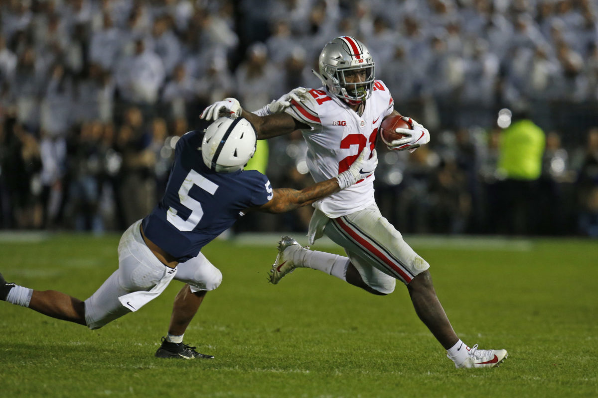 Ohio State WR Parris Campbell stiff arms a defender during a college football game against Penn State.
