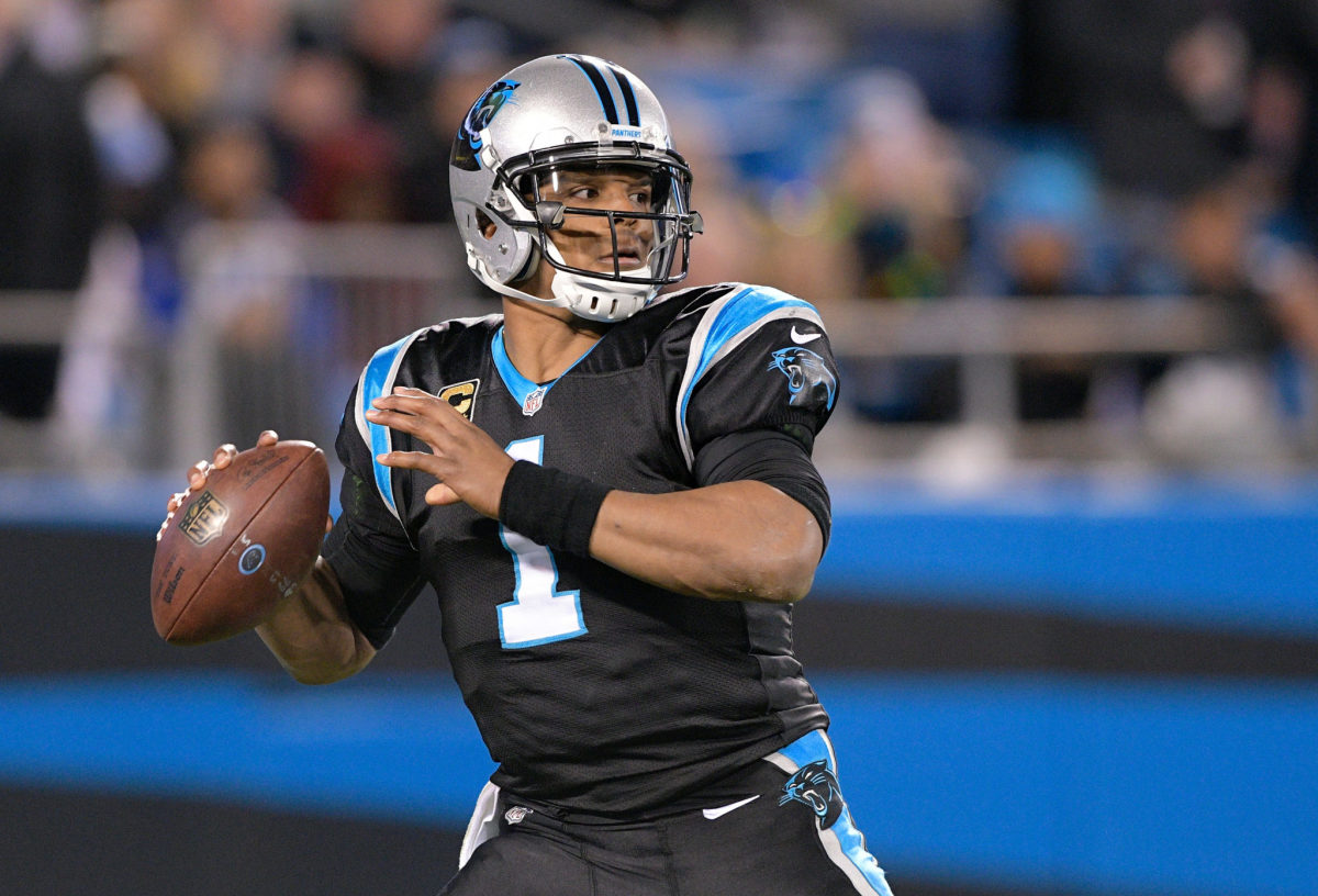 A closeup of Cam Newton throwing a pass during a Panthers game.