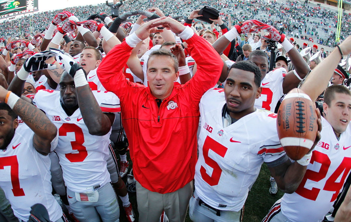 Urban Meyer celebrates by throwing up the "O" after Ohio State beat Michigan State.
