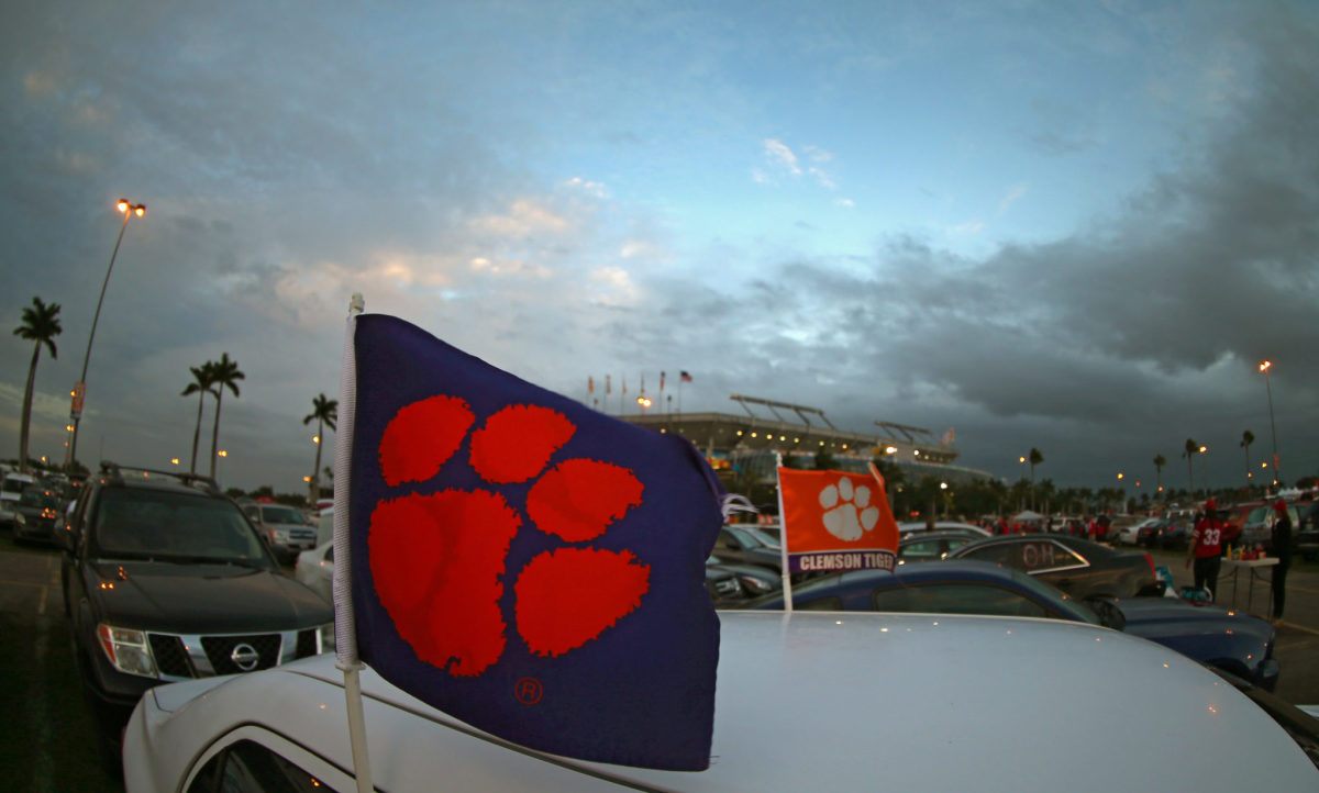 A view of a car with a Clemson flag in the parking lot during a Clemson football game.