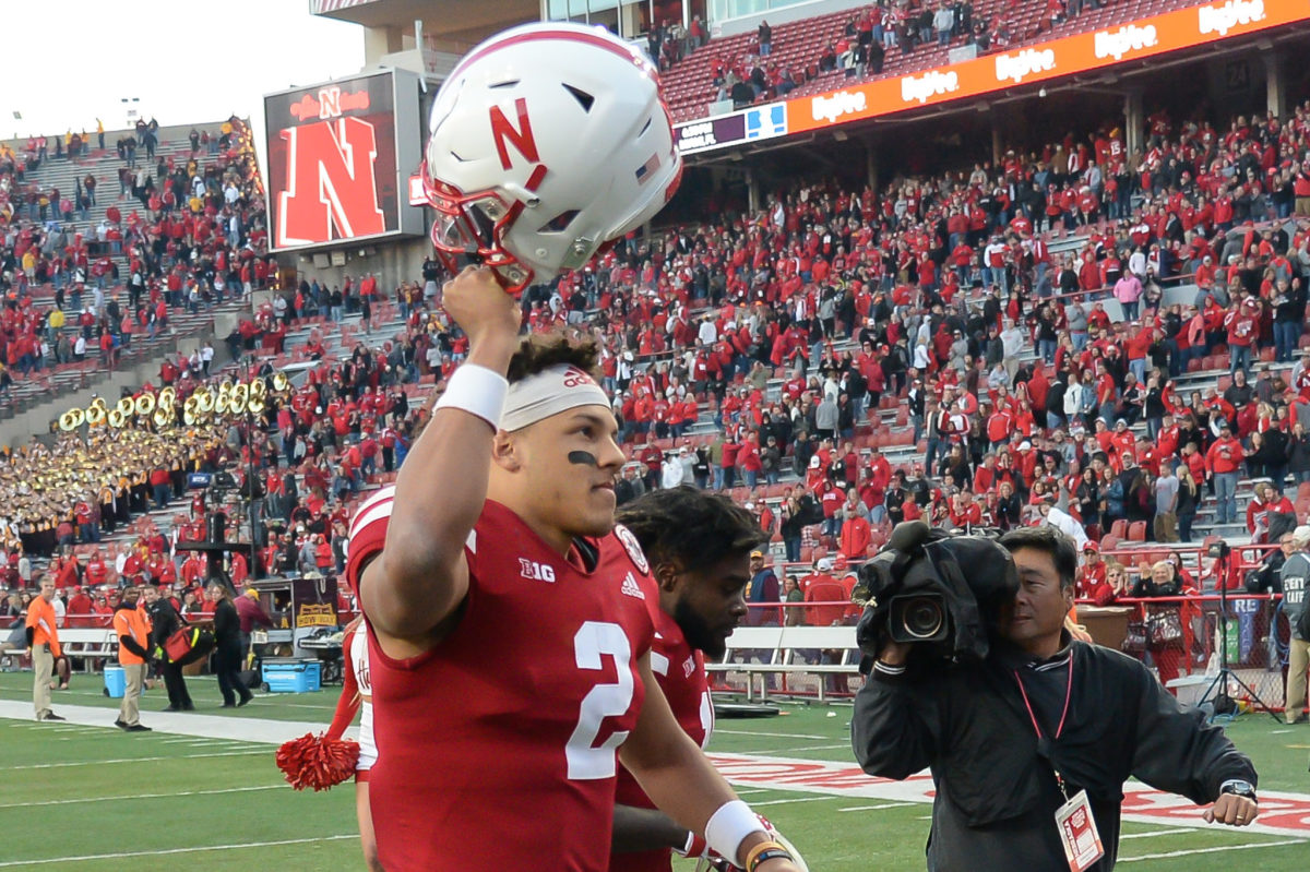Adrian Martinez lifts his helmet in the air for Nebraska after a win during the 2018 college football season.