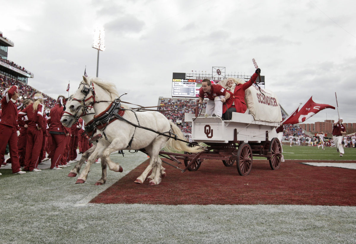 The Sooner Schooner being pulled off the field by two horses.