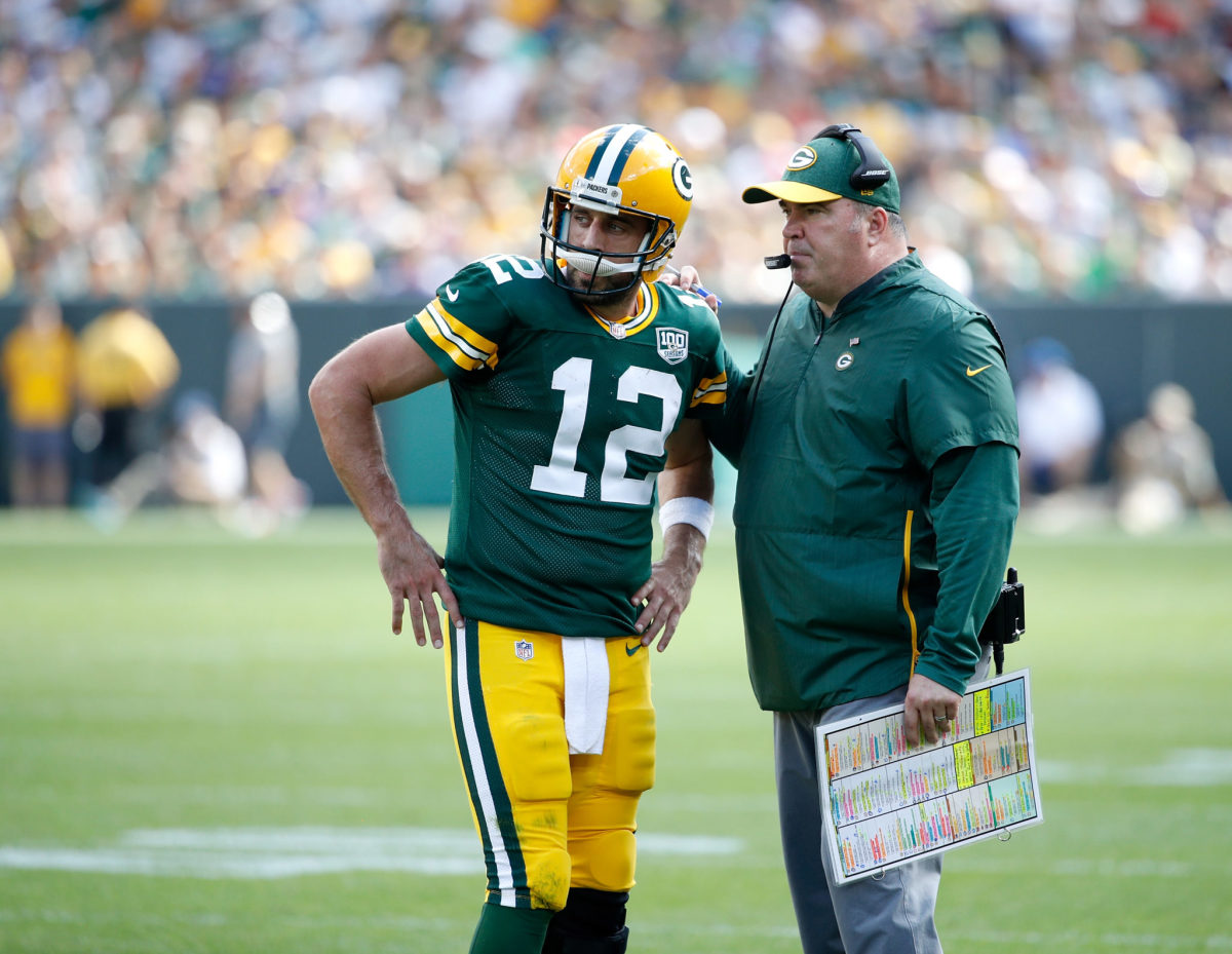 Green bay packers quarterback Aaron Rodgers speaking with Mike McCarthy.