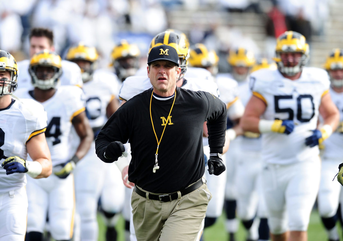 Jim Harbaugh head coach of the Michigan Wolverines runs onto the field prior to the game against the Penn State Nittany Lions.