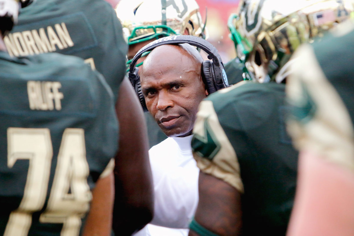 Charlie Strong surrounded by USF football players.