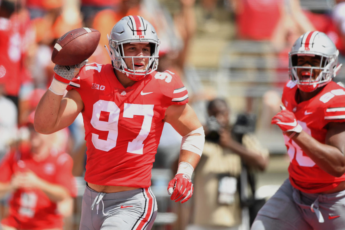 nick bosa celebrates with the football in a game at ohio state