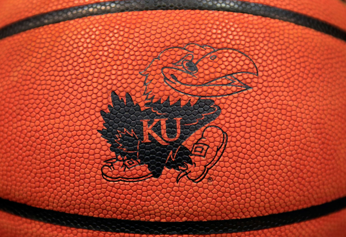 A closeup of a basketball with Kansas' logo on it.