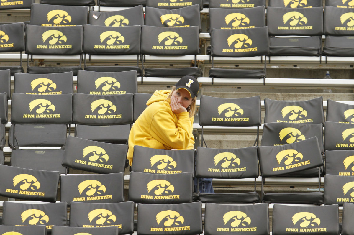 An Iowa fan sitting by herself before a football game.