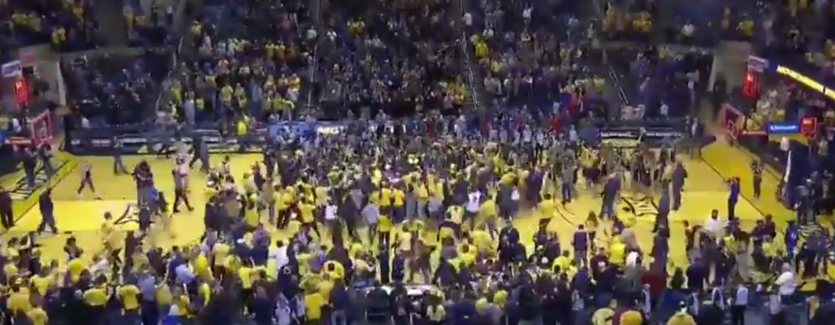 West Virginia fans rush court after win over Kansas.