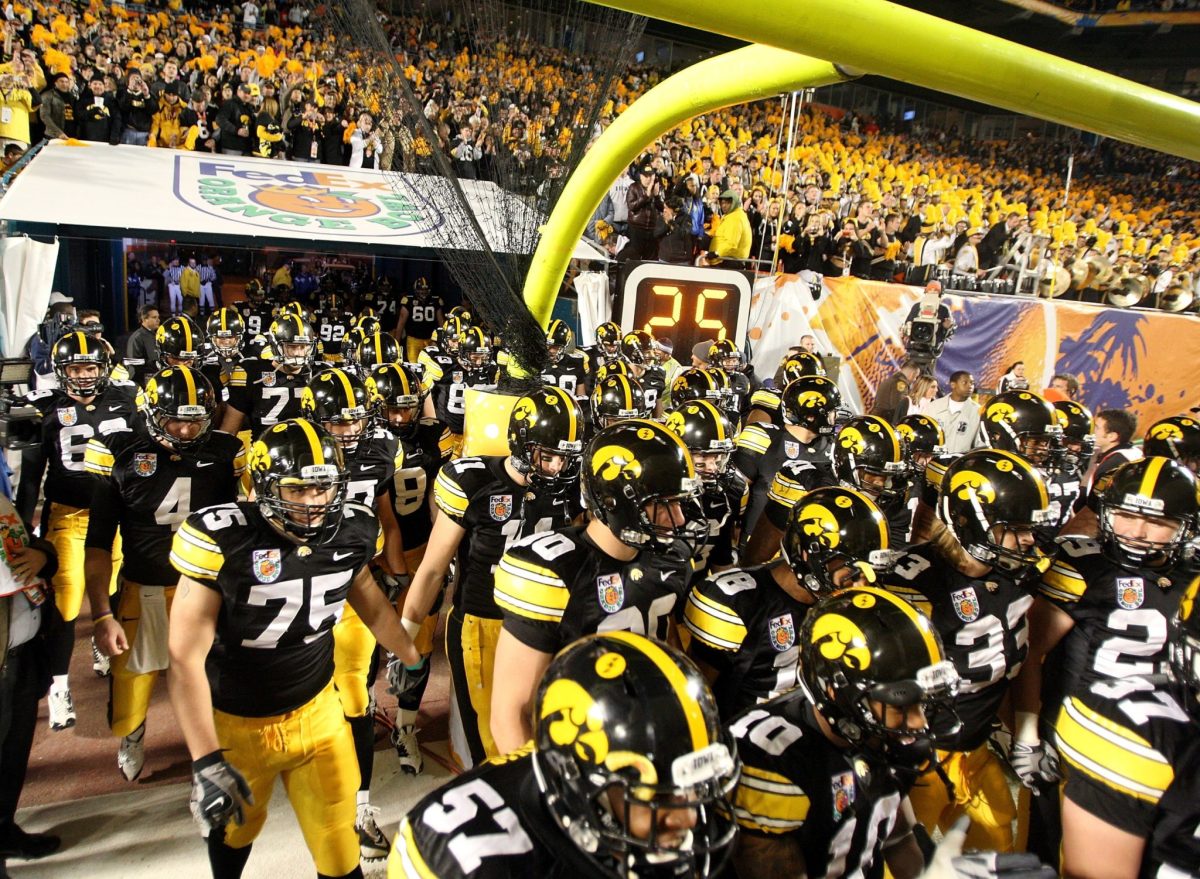 Iowa football players walk out onto the field.