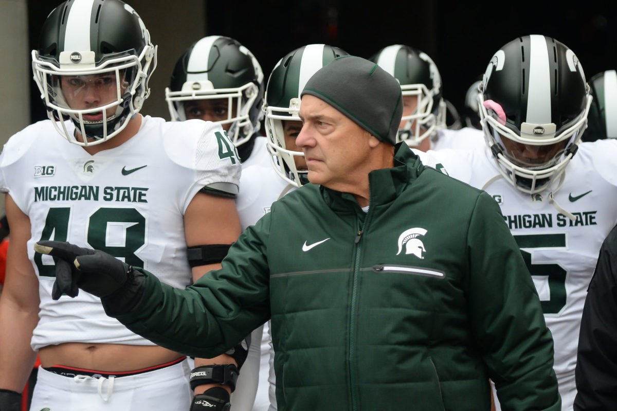 Mark Dantonio leading his team onto the field before a game.