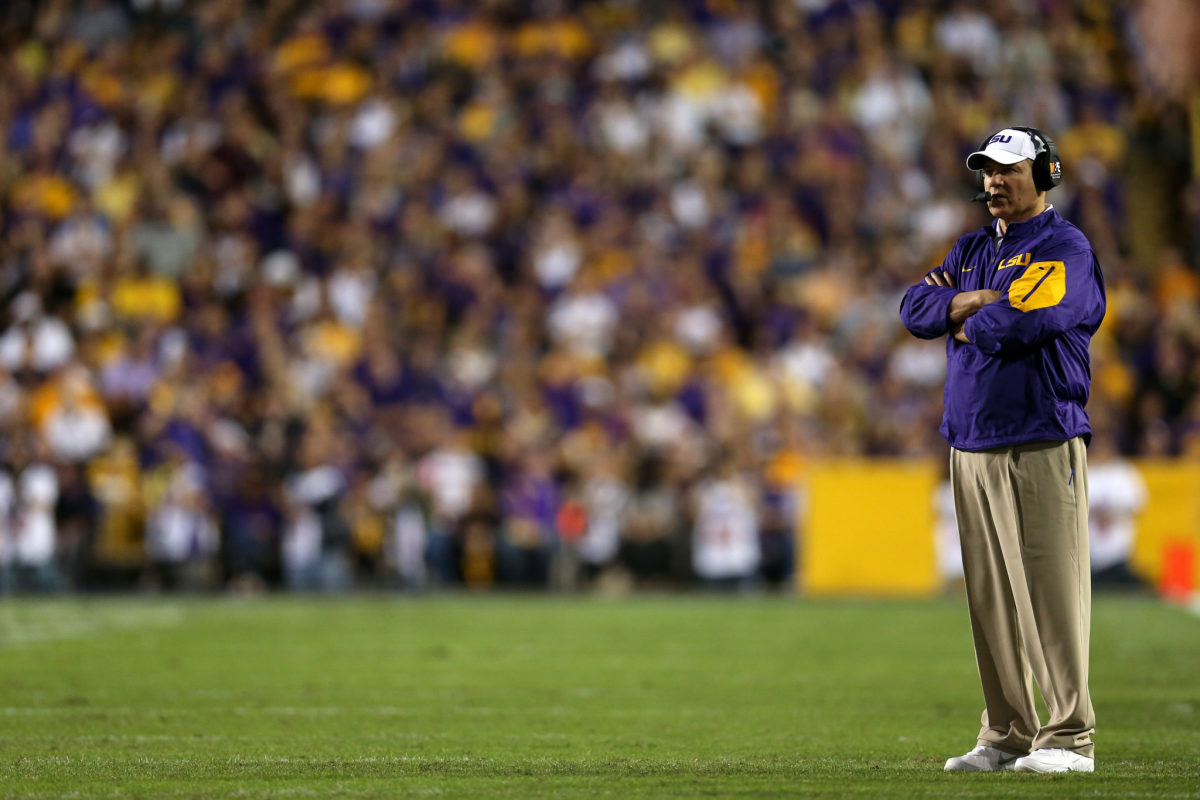 Les Miles stands on the field during a game.