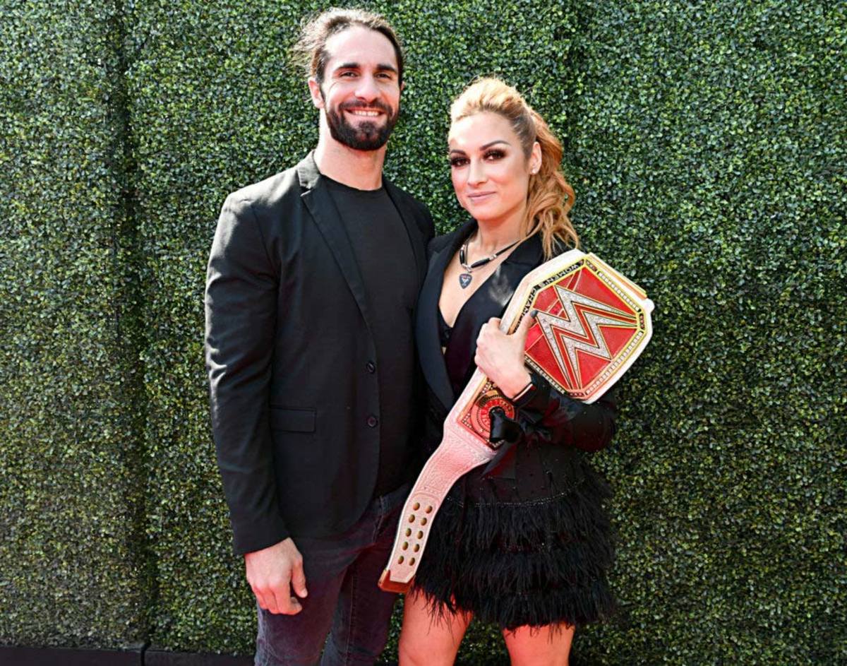 Becky Lynch poses with Seth Rollins.