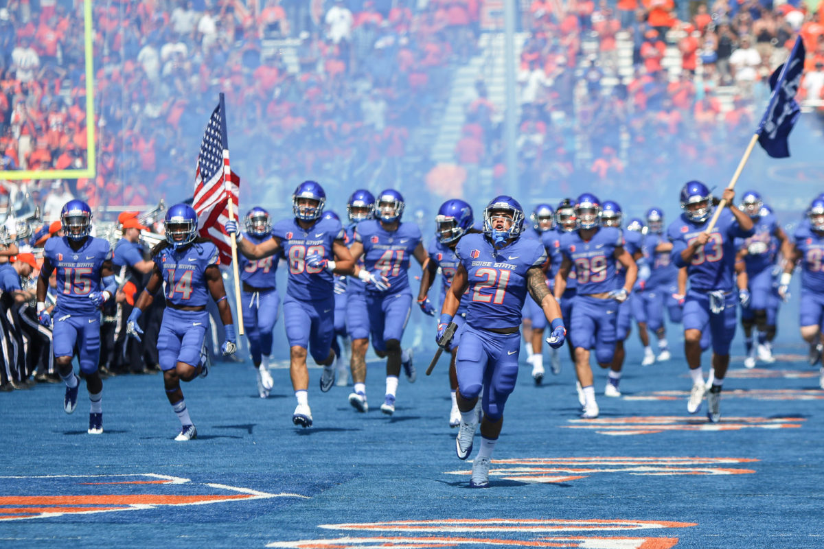 Boise State's football team running onto the field.