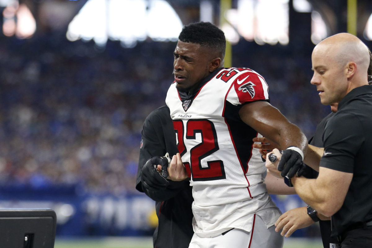 Keanu Neal exits the field in pain after being injured.