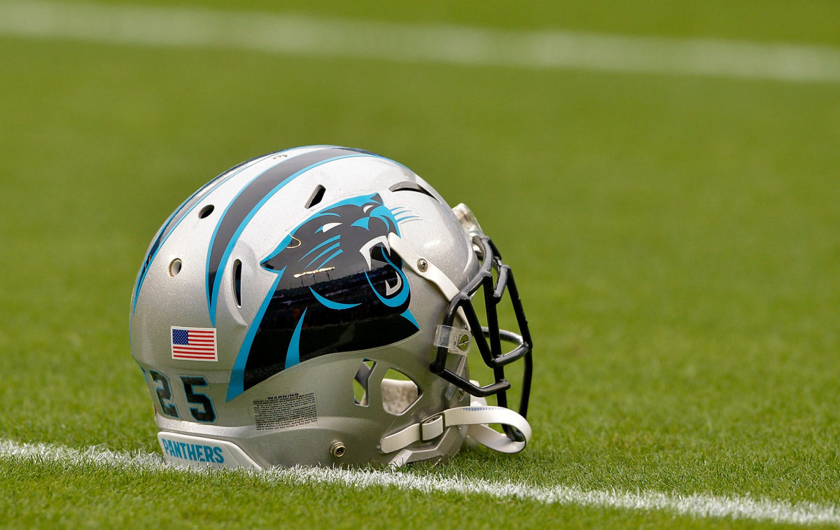 A Carolina Panthers helmet sitting on the field.