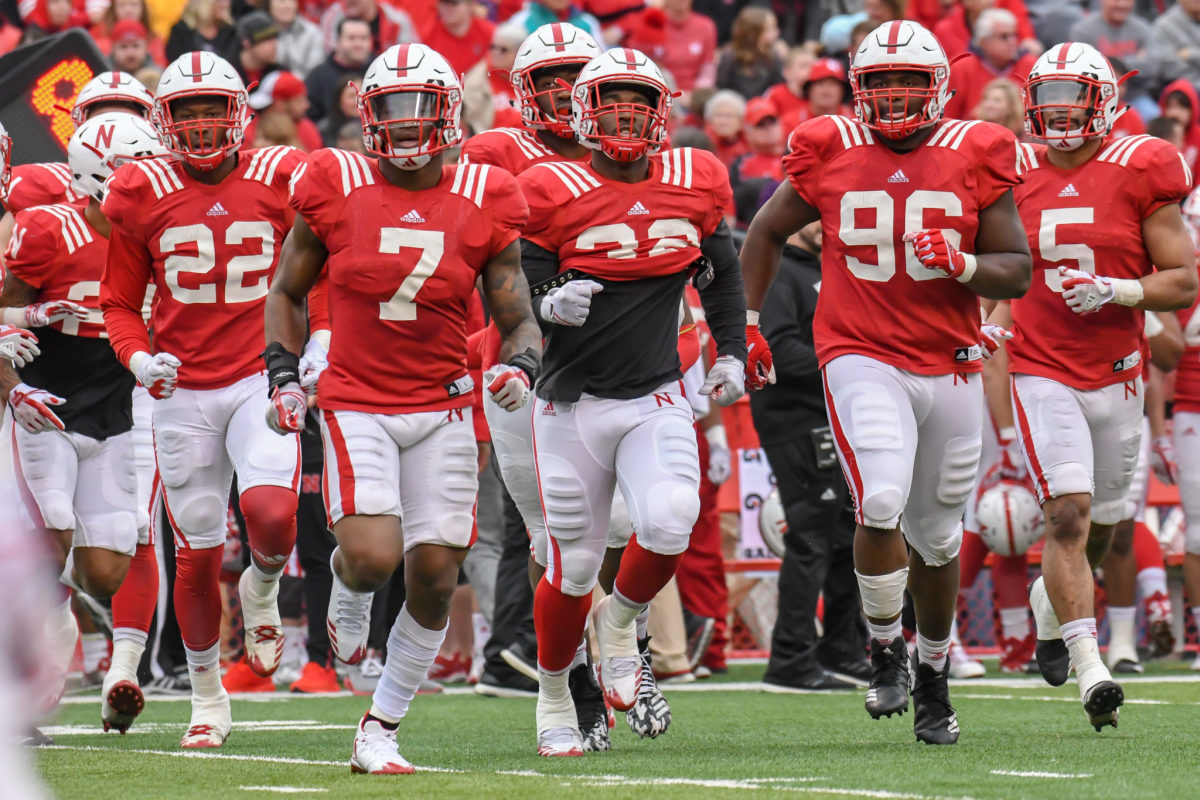 Big Ten program Nebraska football defenders Alex Davis, Mohamed Barry, Pernell Jefferson, Carlos Davis, and Dedrick Young run out onto the field during spring game.