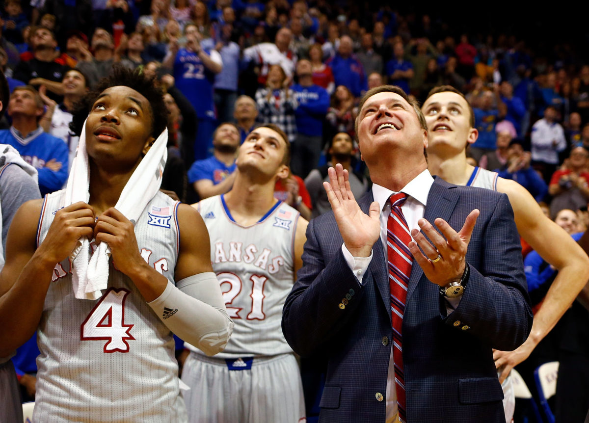 Kansas coach Bill Self clapping with Devonte' Graham by his side.