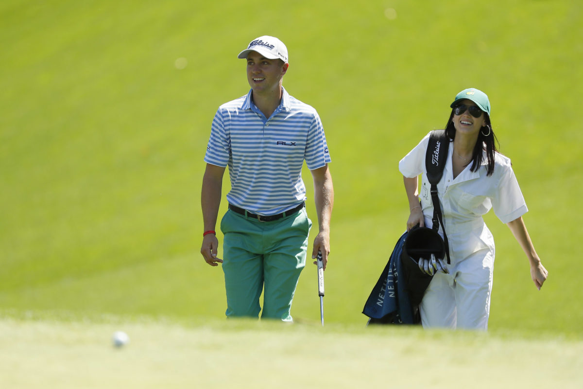 Justin Thomas walking on the golf course with his girlfriend.