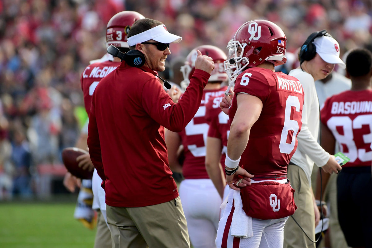 Lincoln Riley standing next to Baker Mayfield on the sideline during an Oklahoma Sooners game.