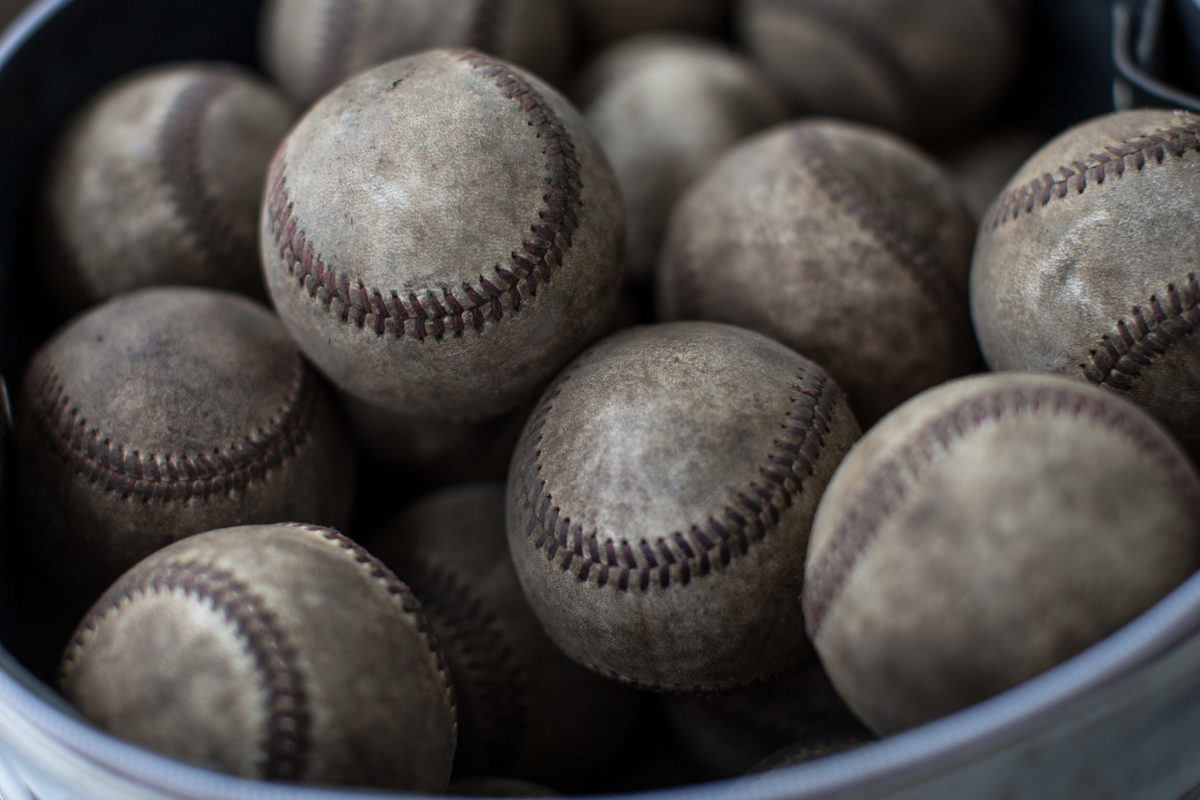 A pile of used baseballs in a dugout.