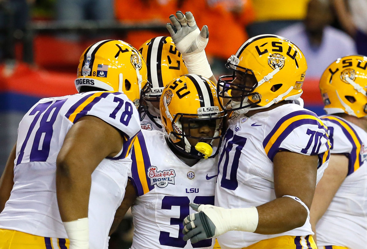 Vadal Alexander and other LSU football players celebrate a play.