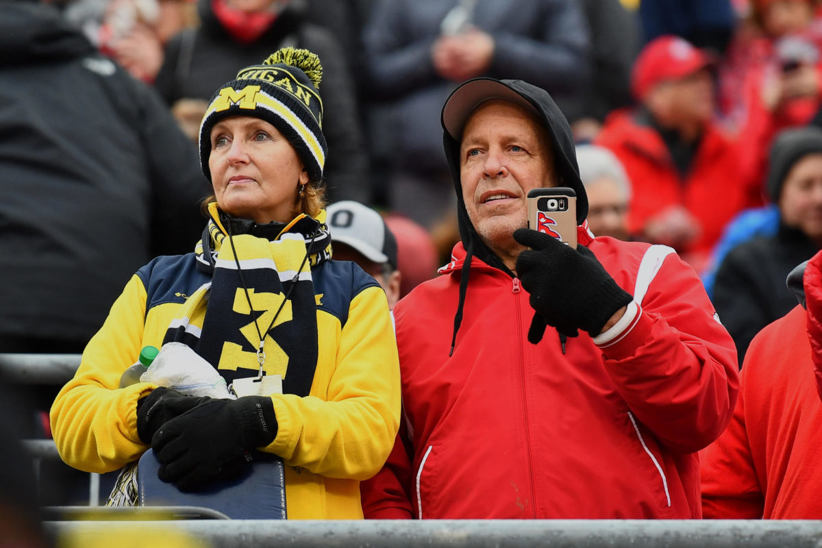 A Michigan fan in the stands with an Ohio State fan before a game.