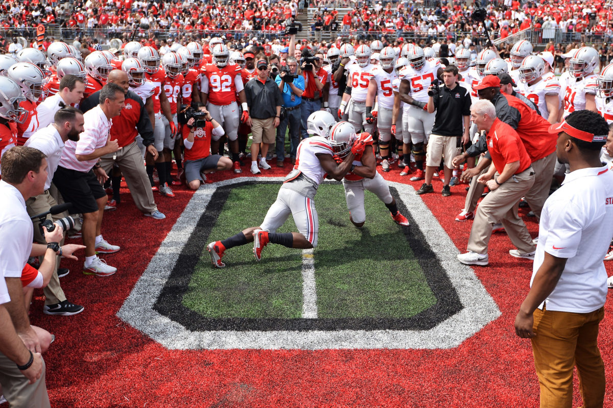 Two Ohio State football players performing the circle drill during a practice.